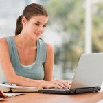 Beautiful young woman using laptop and smiling