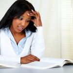 Portrait of a stressed young black woman studying at soft colors composition